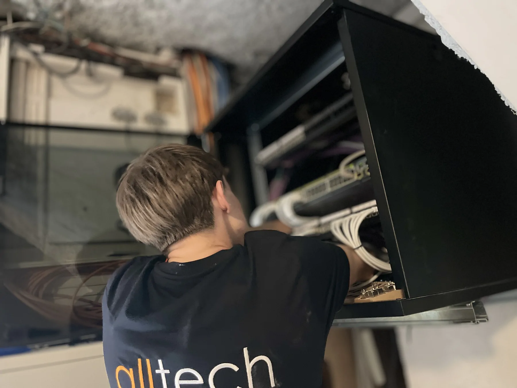Intervenant Alltech devant les raccordements d’une baie réseau.