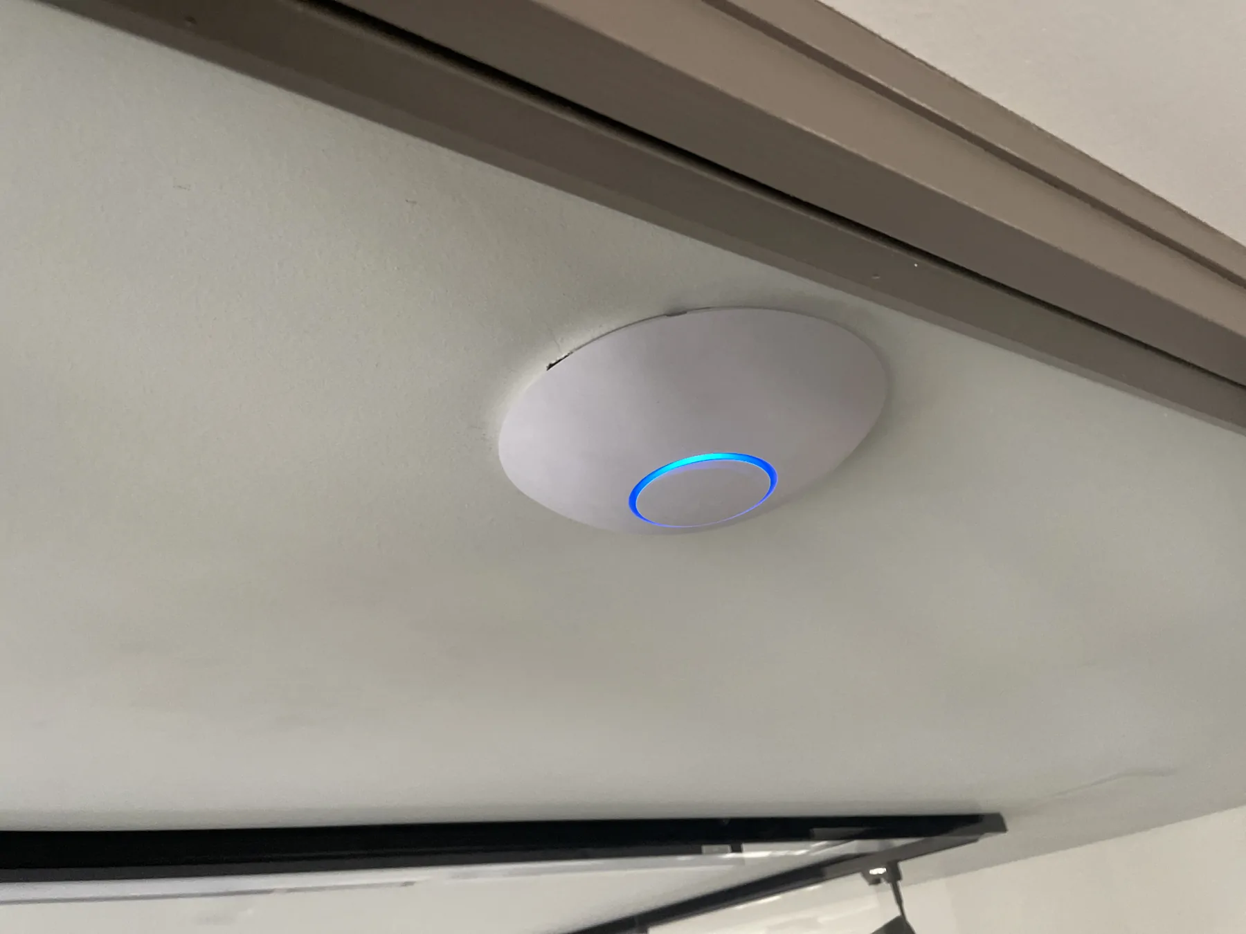 Point d’accès Wi-Fi installé au plafond au-dessus d’un téléviseur.